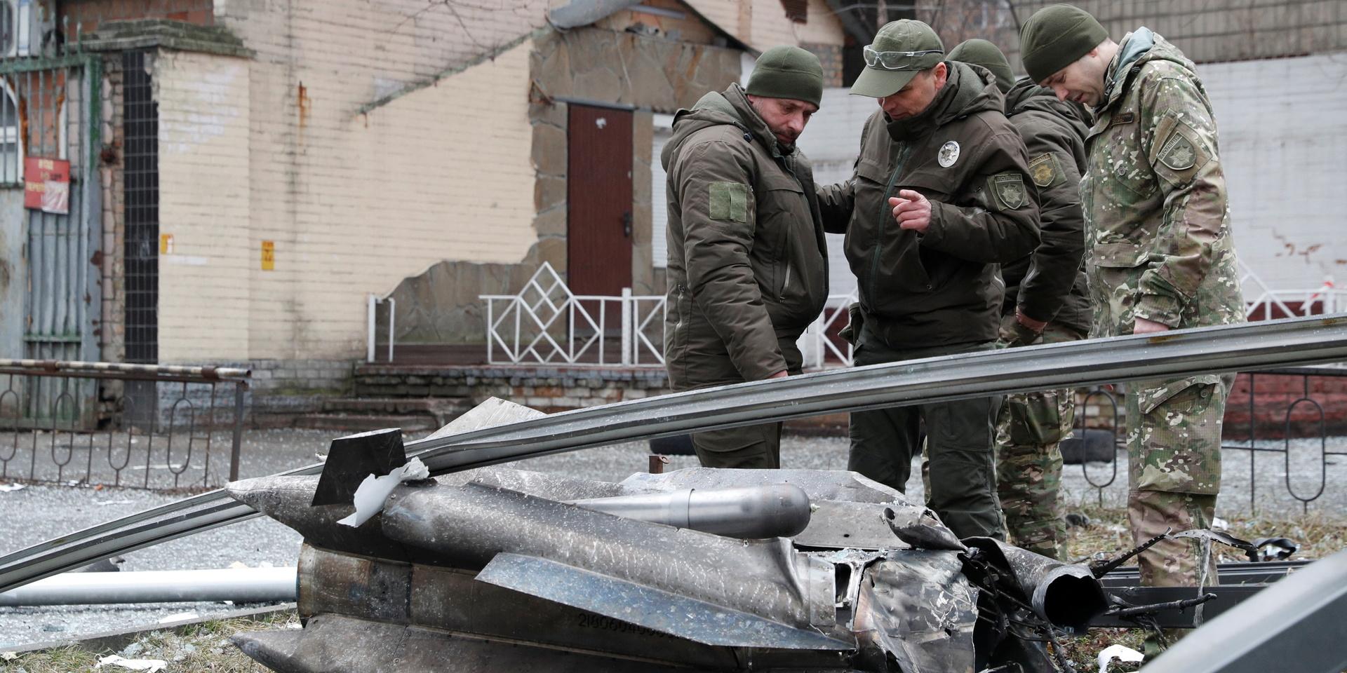 Ukrainsk militär inspekterar resterna av en missil som landat på gatan i Kiev.