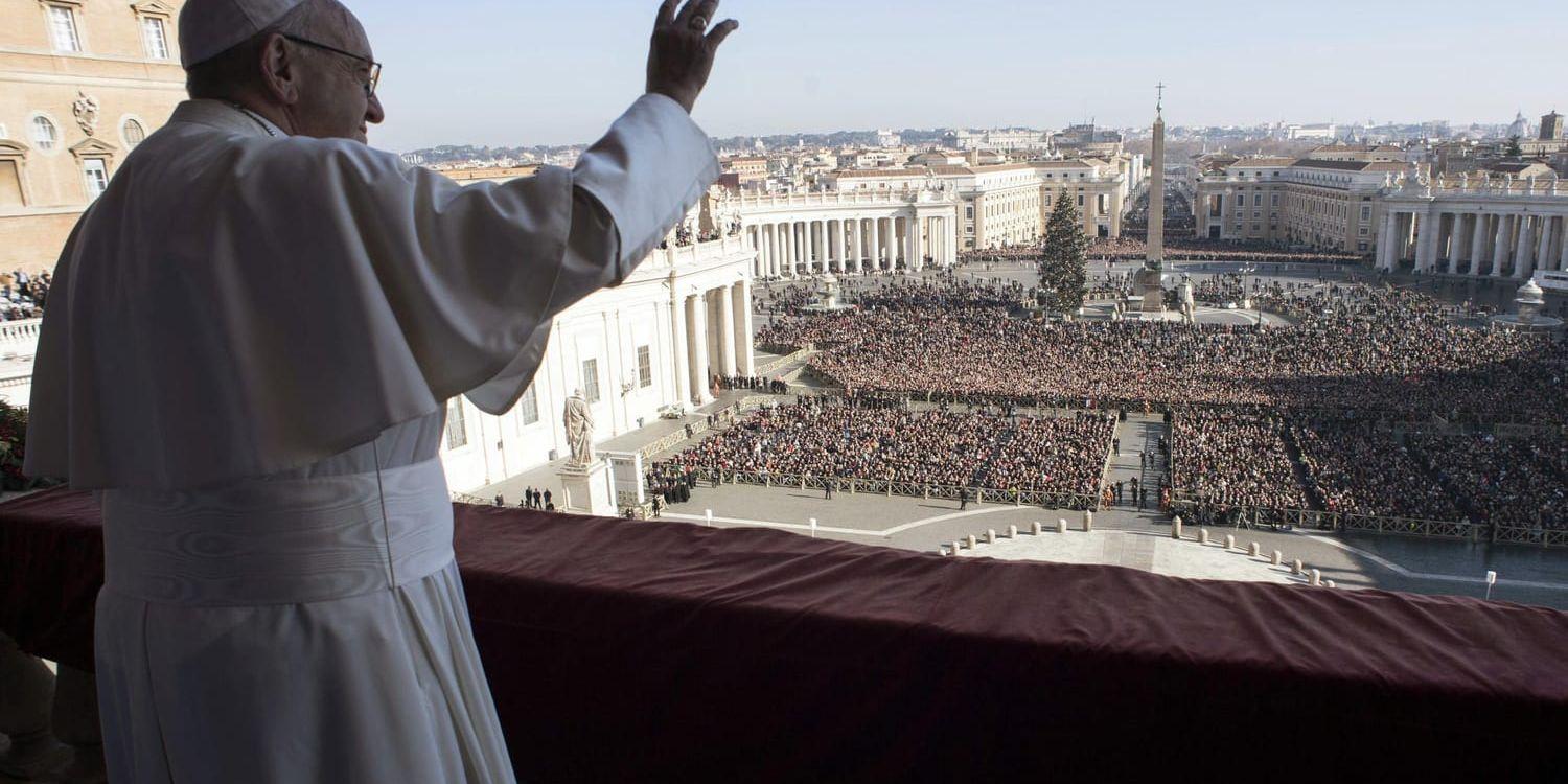 Påve Franciskus vinkar till de troende som följer hans juldagstal från Petersplatsen.