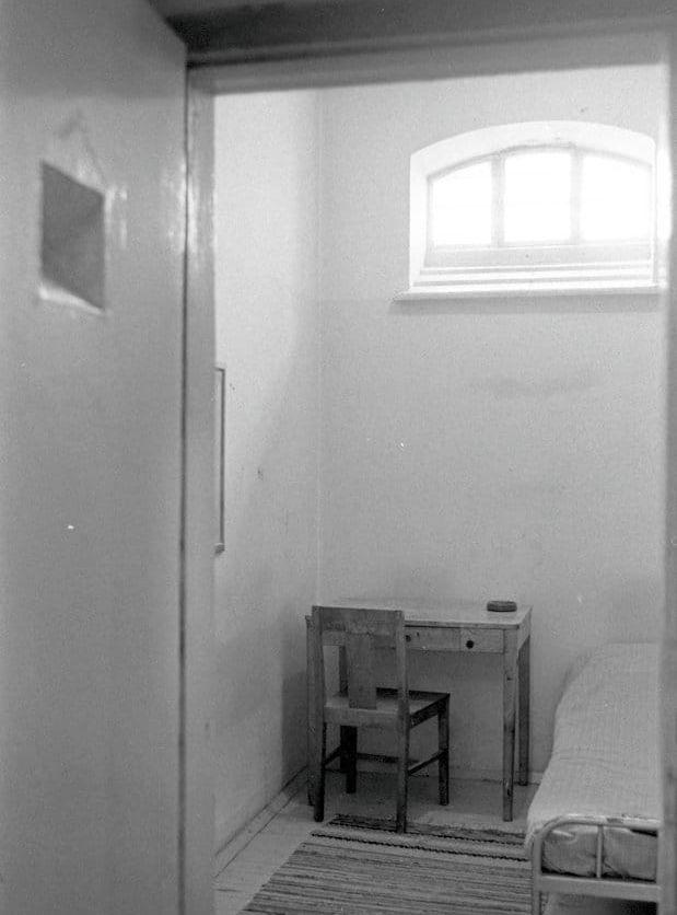 En klassisk svensk fängelsecell, med ett litet högt sittande fönster. 