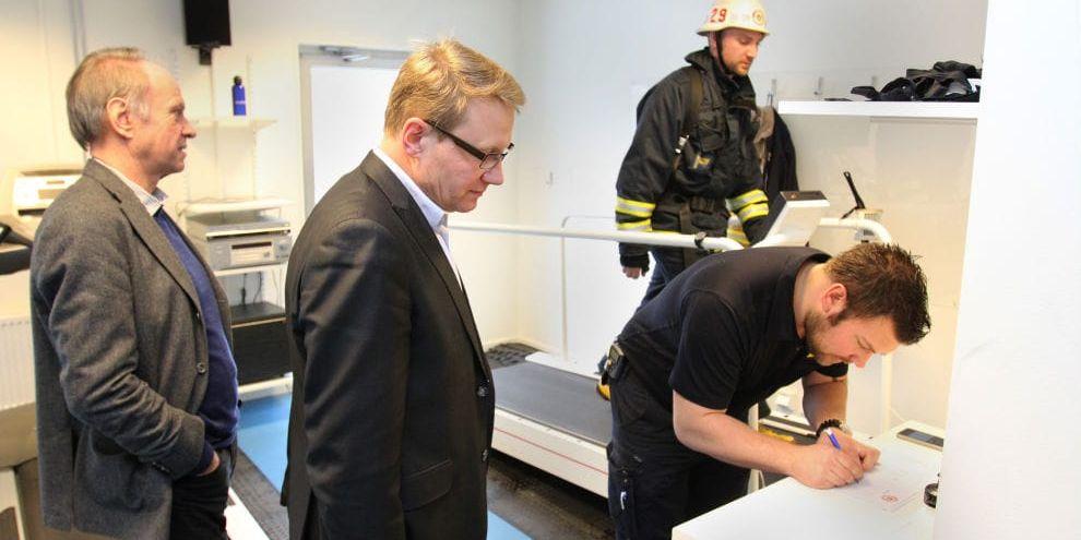 Svettigt. Christer Johnsson och Erling Cronqvist informeras av Andreas Randevik om hur uttagningstesterna för brandmän går till. I bakgrunden kämpar Kasper Lillemose på gångbandet.