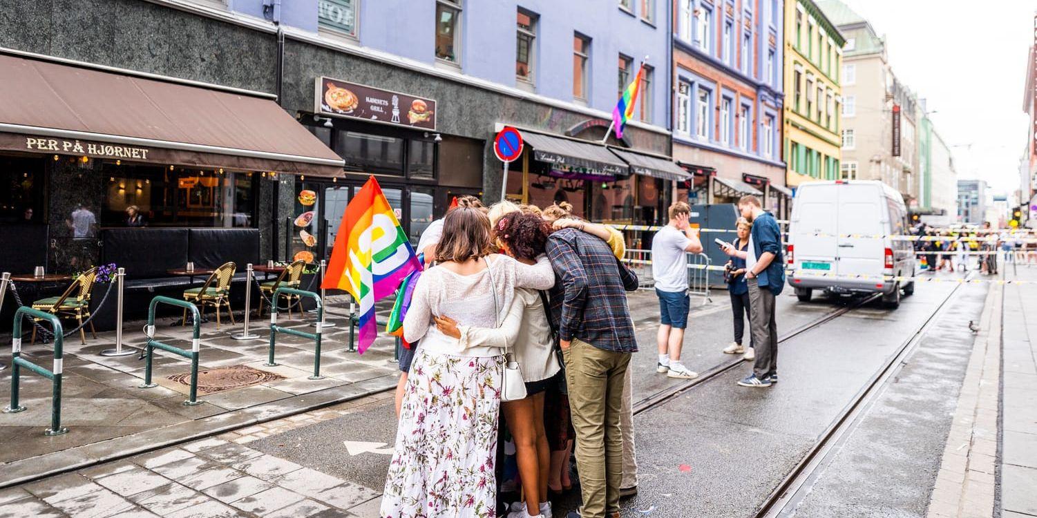 Ungdomar omfamnar varandra på platsen för masskjutningen i centrala Oslo i juni.