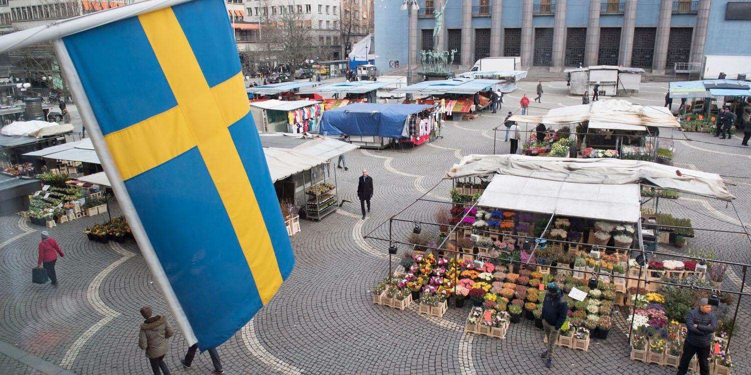 Svenska flaggan vajar över torghandeln på Hötorget i Stockholm. Handlarna känner våroptimism, enligt Svensk Handel.