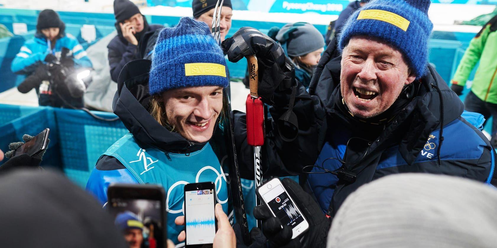 OS-silvermedaljören Sebastian Samuelsson och Sveriges förbundskapten Wolfgang Pichler firar efter herrarnas jaktstart.