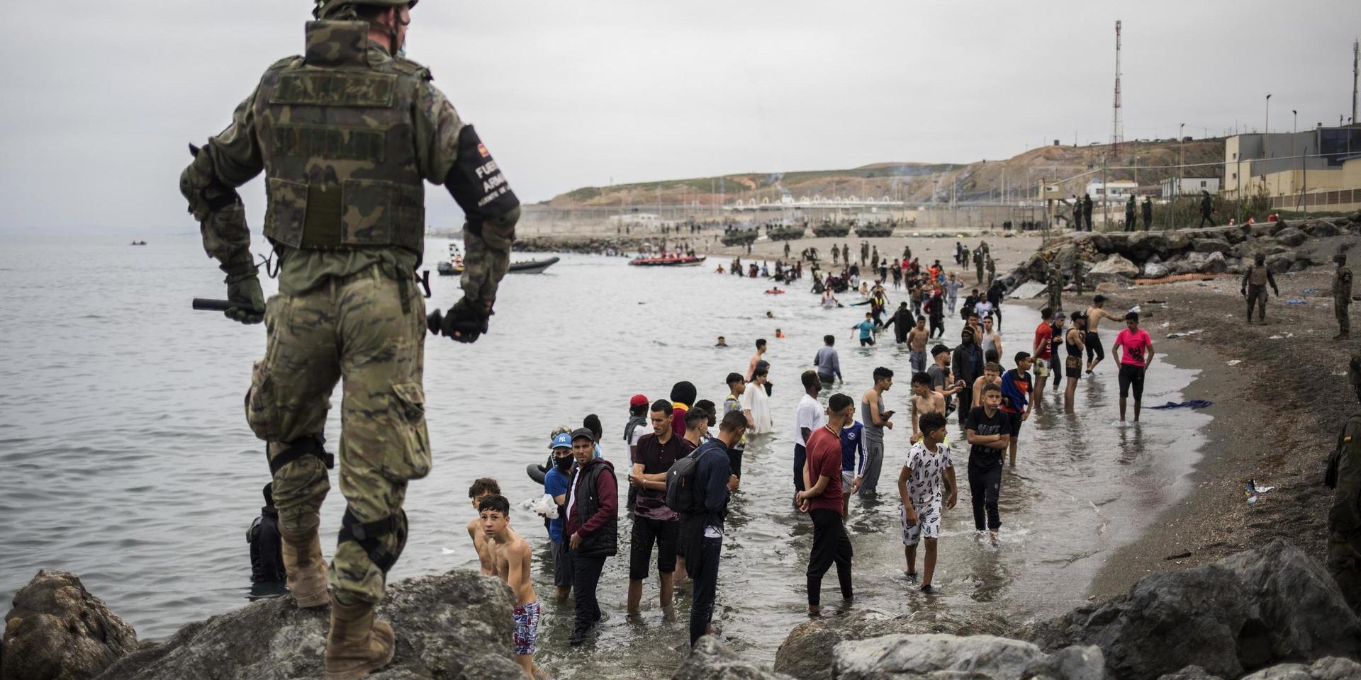 Människor som har simmat eller vadat till Ceuta står i vattnet sedan gränsområdet i den spanska enklaven spärrats av.