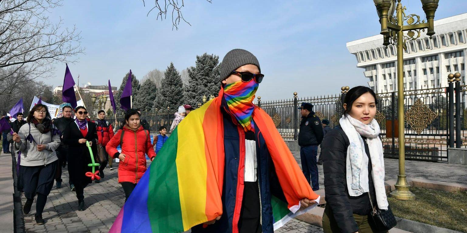 Människor marscherar förbi parlamentsbyggnaden i centrala Bisjkek i Kirgizistan på internationella kvinnodagen den 8 mars.