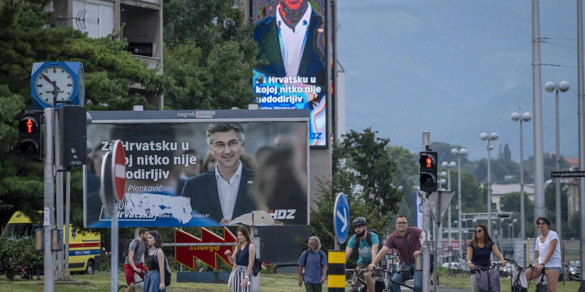 Zagreb-bor går förbi premiärminister Andrej Plenkovićs valaffischer.