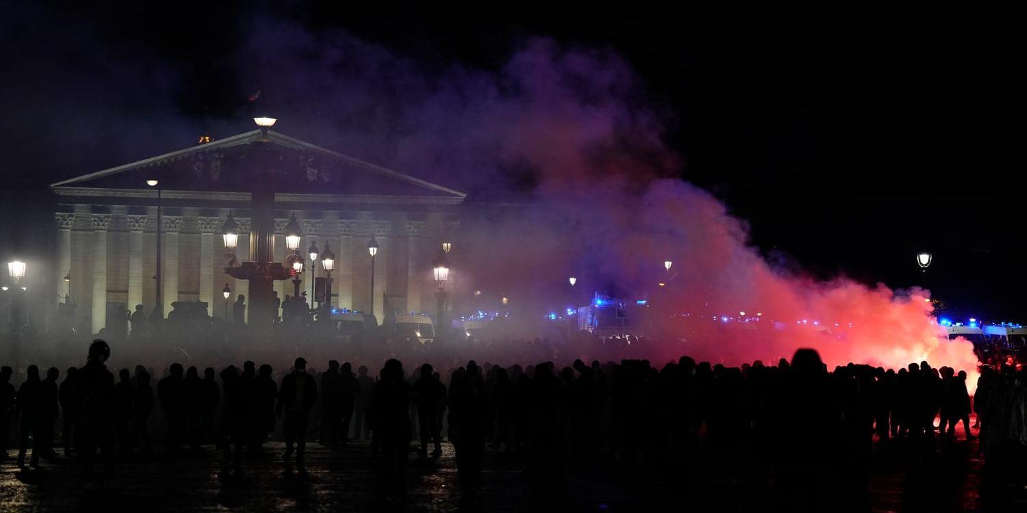 Demonstranter som under fredagskvällen samlats framför parlamentsbyggnaden i Paris.