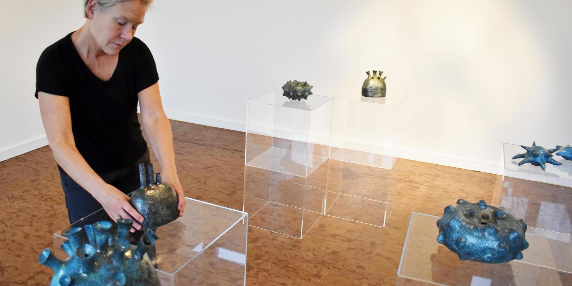 Lisbeth Forsberg arrangerar keramikverken i sin utställning.